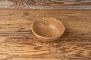 Masada boş ahşap kase, ahşap masa üstünde tabak, hafif kırsal tabak modeli, metin için fotokopi alanı olan eko biyo mutfak afişi.