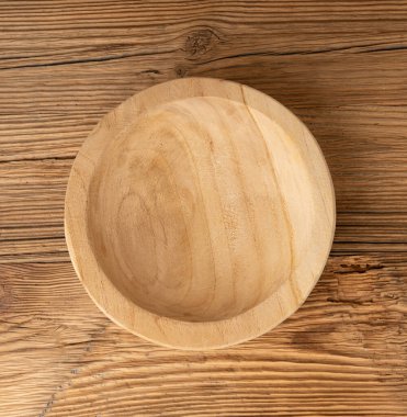 Masada boş ahşap kase, ahşap masa üstünde tabak, hafif kırsal tabak modeli, metin üst görünümü için fotokopi alanı olan eko biyo mutfak afişi.