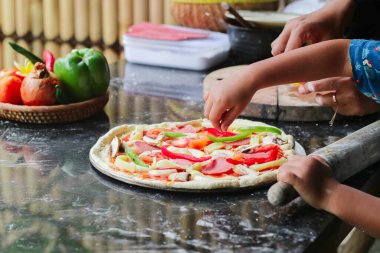 Çocuk ekmek parası kazanıyor, yumrukluyor ve bir top şekline bürünüyor, tahtadan bir masa yüzeyinde, annesinin de yardımıyla..