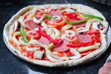 Mermer bir bluzda pizza margherita hazırlıyorum. Pizzaolo kabuğa pizza hamuru koyar. Seçici odak