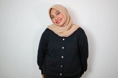 İzole edilmiş beyaz arka planda duran mutlu Asyalı genç Müslüman kadın. Stüdyoda abaya ve tesettüre bürünmüş güzel bir muslimah.