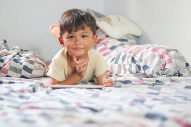 Evde dijital tabletle oynayan küçük bir çocuğun portresi, dizüstü bilgisayar kullanan beyaz bir çocuk. Hafta sonu tatili boş zaman eğitimi