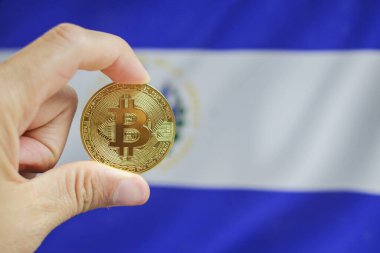 Klavye arka planında Bitcoin yakın plan, Bitcoin üzerinde El Salvador bayrağı gösterilir.