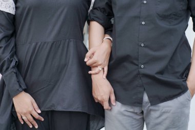 Happy stylish romantic couple embracing, looking at camera standing together at new home. Portrait of smiling attractive confident best friends wearing colorful clothing. Love, relationship concept clipart