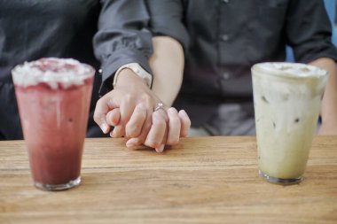 Asian couple relaxing in a coffee shop clipart