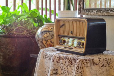 Eski moda bir radyo çalar ahşap bir masanın üzerinde durur. Köyde şık bir mutfak, pencereden gün ışığı. Boşluğu kopyala