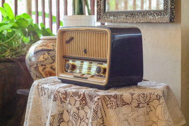 Eski moda bir radyo çalar ahşap bir masanın üzerinde durur. Köyde şık bir mutfak, pencereden gün ışığı. Boşluğu kopyala