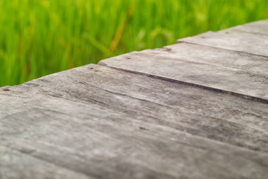 Pirinç tarlasında ahşap eski masa ve bulut arka planı. Ürün yerleştirme ya da ön plandaki masanın üstüne odaklı montaj için. Boş ahşap kahverengi raf. raflar