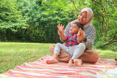 Mutlu tatiller, anne ve kızı parkta birlikte oynuyorlar..