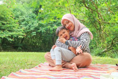 Güzel Asyalı anne ve oğlu piknik yapıyor ve göl ve dağ yakınındaki çayırpaskalya yaz partisinde. Tatil ve Tatil. İnsanlar yaşam tarzı ve Mutlu aile hayatı kavramı. Taylandlı kişi