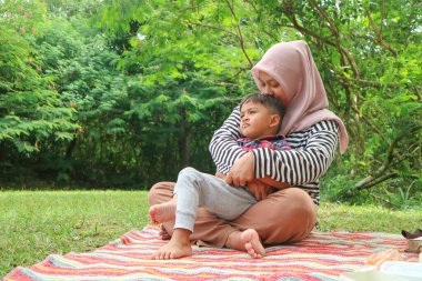 Güzel Asyalı anne ve oğlu piknik yapıyor ve göl ve dağ yakınındaki çayırpaskalya yaz partisinde. Tatil ve Tatil. İnsanlar yaşam tarzı ve Mutlu aile hayatı kavramı. Taylandlı kişi