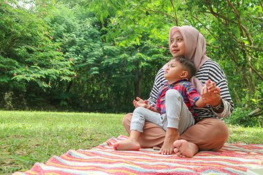 Mutlu tatiller, anne ve kızı parkta birlikte oynuyorlar..