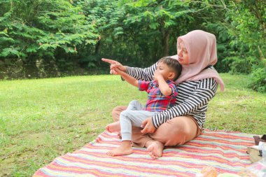 Güzel Asyalı anne ve oğlu piknik yapıyor ve göl ve dağ yakınındaki çayırpaskalya yaz partisinde. Tatil ve Tatil. İnsanlar yaşam tarzı ve Mutlu aile hayatı kavramı. Taylandlı kişi