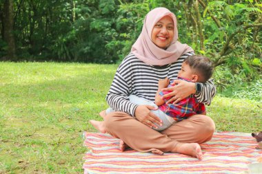 Geleneksel kıyafetleriyle Orta Doğulu aile Dubai 'de modern İslami anne ve oğlu eğleniyor.