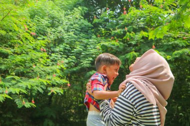 Genç Müslüman anne ve tatlı küçük oğlu güzel bir yaz günü tarlada.