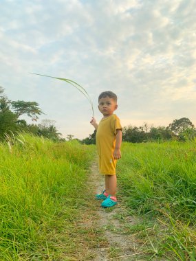 Çayırda oynayan Asyalı çocuk