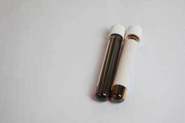 Laboratory worker's hand in rubber glove holding test tube with blood sample on light background with space for text