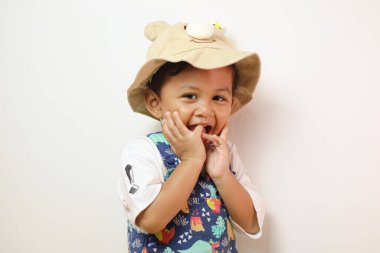 Şaşırmış çocuk beyaz arka planda avuçlarında avuçlarını tutuyor ve yukarı bakıyor.