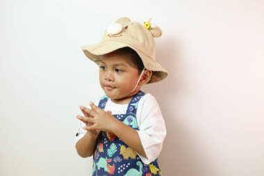 Beyaz arka planda solda duran Asyalı bir çocuğun portresi