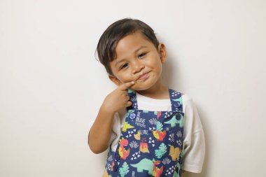 Beyaz bir arka planda şirin poz veren Asyalı bir çocuğun portresi