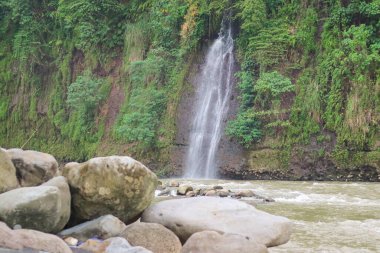İzlanda 'da kasvetli bir günde yazın uçurumdan akan güçlü şelalenin güzel manzarası.