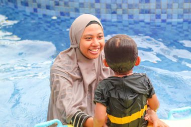 Su parkındaki havuzda mutlu bir aile.