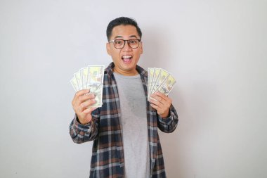 Paralı Asyalı bir öğrenci. Kameraya bakıyorum. gri arkaplan