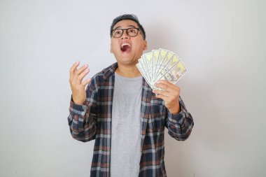 Kot ve gözlük takan yakışıklı Asyalı genç adam, beyaz arka planda izole edilmiş, el ele tutuşarak sürpriz yapıyor. Kazanan kavramları kutla.