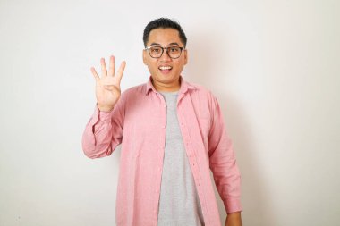 Genç, yakışıklı, sıradan kıyafetler giyen, dört numarayı gösterip işaret eden Asyalı bir adam beyaz arka planda kendine güvenen ve mutlu bir şekilde sırıtıyor.