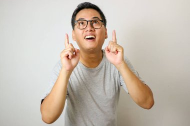 Yakışıklı Asyalı gri gömlekli, parmak ucunda tek başına duruyor.