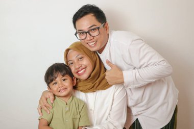 Sevgi ve beraberlik saçan neşeli bir aile gülümseme, sıcaklık ve değerli mutluluk bağlarıyla dolu mükemmel bir anı yakalıyor..