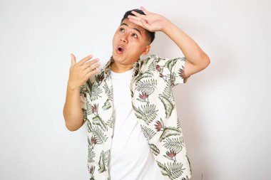 Yetişkin Asyalı adam yukarı bakıyor ve terliyor.