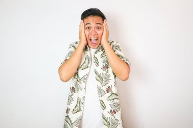 İnsanlar, İnsan Duyguları ve Duyguları Konsepti. Şaşırmış, korkmuş, ağzı açık, yüzüne dokunan ve kameraya bakan Asyalı adamın portresi, izole edilmiş beyaz stüdyo duvarı.