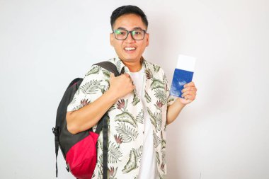 Pasaportu, bileti ve akıllı telefonu olan Asyalı genç adamın gülümsemesi ve bakışıyla havaalanından ayrılırken seyahat ve insanların yaşam tarzı konsepti