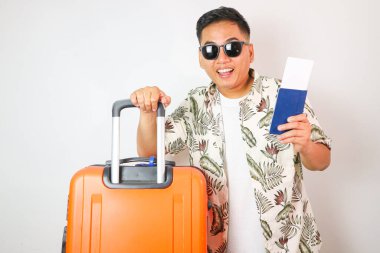 Elinde uçak bileti ve pasaportuyla beyaz stüdyo geçmişine izole edilmiş çekici Asyalı genç bir turist.