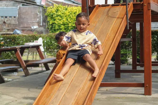 Asyalı çocuk parkta oynuyordu ve gülümsüyor ve gülüyordu.