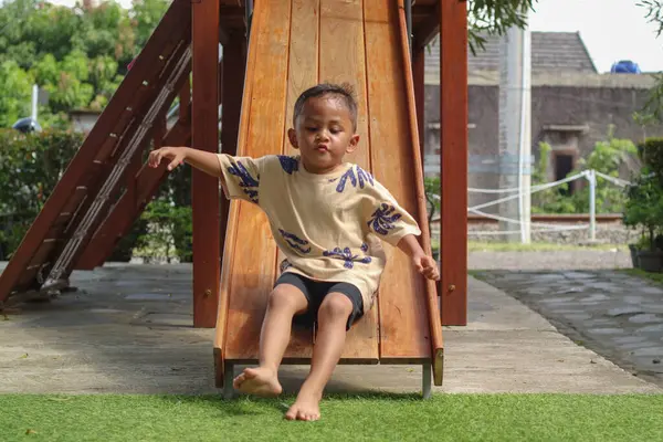 Mutlu çocuk, Asyalı bebek parkta renkli çocuk parkında kayıyor.