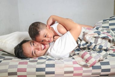 Baba ve kızı yatakta gülüp kaynaşıyorlar. Baba ve oğul evde vakit geçiriyorlar. Eğlenceli aşk aile yaşam tarzı Babalar Günü konsepti