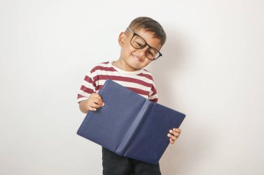 Gözlük takan ve açık kitap okuyan heyecanlı Asyalı bir çocuk. Gözlüklü şirin bir öğrenci. Çalışmaktan ve öğrenmekten zevk alıyor.