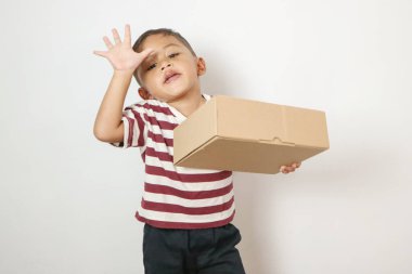 Kahverengi bir kutu tutan mutlu Asyalı çocuk portresi. Teslimat konsepti.