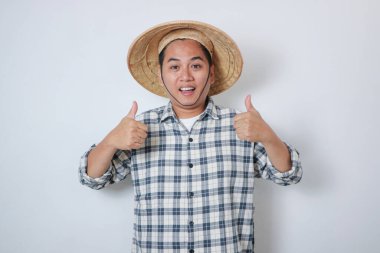 Portre mutlu adam gülümsüyor. Çiftçi başparmağı tişörtle dikilip pirinç tarlasına bakıyor.