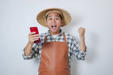 İzole edilmiş beyaz arka planda dururken cep telefonu kullanan çiftçi