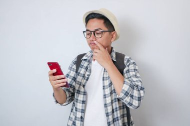 Traveler man hold mobile phone thinking about holiday isolated