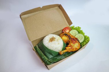 Izgara tavuk, pilav, biber ezmesi, bir dilim salatalık ve marul yaprağı ile servis edilir. Nasi ayam bakar lalapan, Endonezya ızgara tavuğunun otantik tarifi..