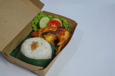 İçinde kızarmış tavuk ve taze sebzeler olan pirinç kutusu.