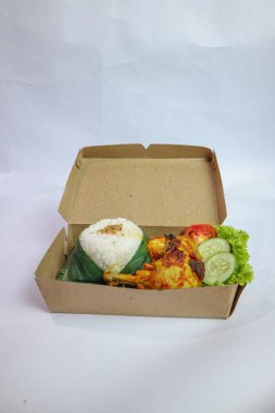 Yemek kutusu. Pirinç, ızgara tavuk ve beyaz arka planda sebze..