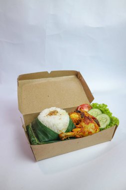 Kızarmış tavuk ve taze yeşil sebzeli pirinç kutusu.