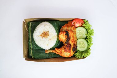 Kızarmış tavuk, pilav, biber ezmesi, salatalık ve marul yapraklarıyla servis edilir. Nasi ayam bakar lalapan, Endonezya ızgara tavuğunun otantik tarifi..