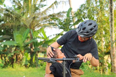 Kırsal kesimdeki baba ve oğlu birlikte bisiklete biniyor.