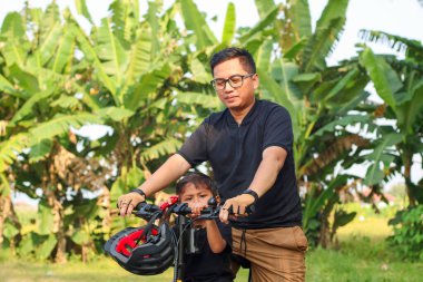 Baba ve oğul birlikte bisiklet sürme